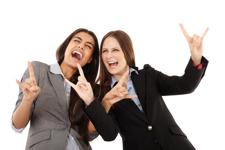 Portrait of businesswomen making a rock and roll hand gesture over white backgroundの写真素材
