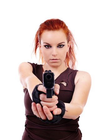 Studio shot of woman holding a gun and aiming  isolated over white backgroundの写真素材