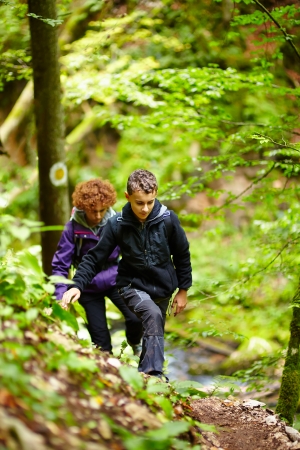 Mother and son walking on a hike trail in a forestの写真素材