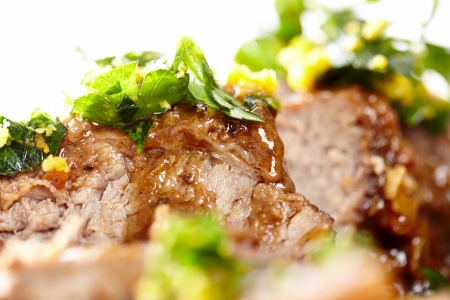 Closeup of slow cooked shin beef with orange gremolata, isolated on white background, selective focusの写真素材