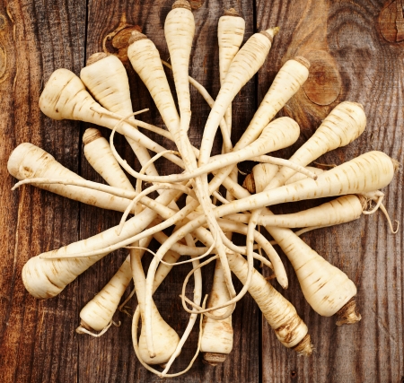 Closeup of a bunch of parsnip on a wooden boardの写真素材