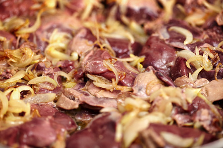 Closeup of chicken liver being roasted in the frying pan with white onionsの写真素材