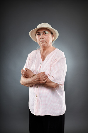 Studio portrait of a caucasian senior woman over gray backgroundの写真素材