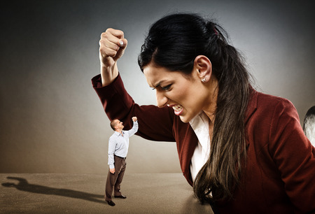 Angry businesswoman ready to crush the courageous subordinate who is confronting herの写真素材