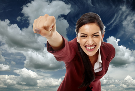 Happy latin businesswoman against beautiful sky with cloudsの写真素材