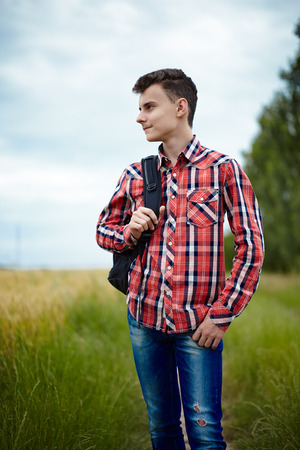 Trendy caucasian teenager boy with school bag outdoorの写真素材