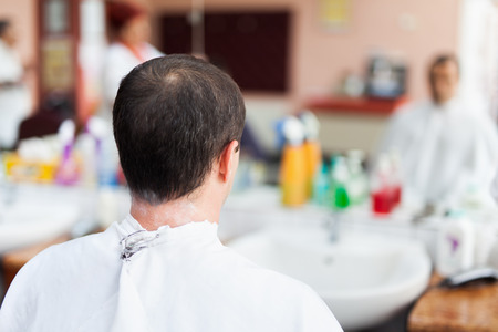 Caucasian man in a barber shop getting a very short haircutの写真素材