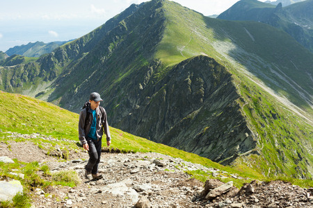 Teenage boy hiking into the rocky mountainsの写真素材