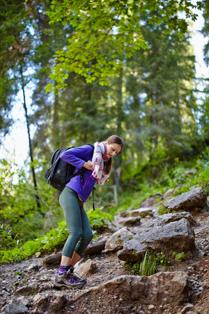 Young hiker woman with backpack on a forest trail in the mountainsの写真素材