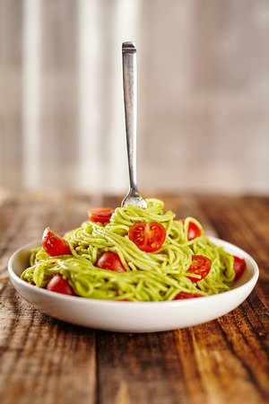 Pasta with avocado sauce and cherry tomatoesの写真素材