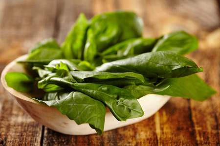 Macro of basil leaves in a wooden bowlの写真素材