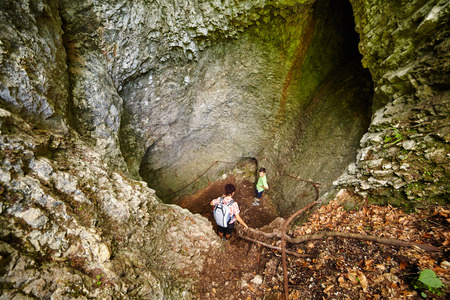 Mother and son hiking through a cave on safety cablesの写真素材