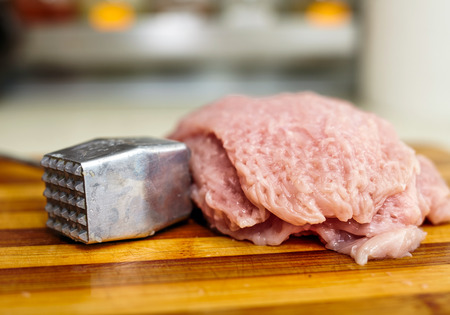 Turkey fillet beaten with the meat tenderizer on a board, for viennese schnitzel recipeの写真素材