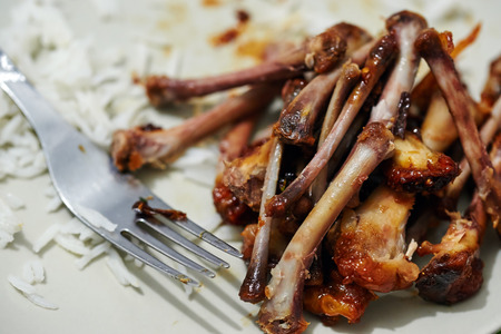 Bunch of chicken wing bones on plate, left after a delicious mealの写真素材