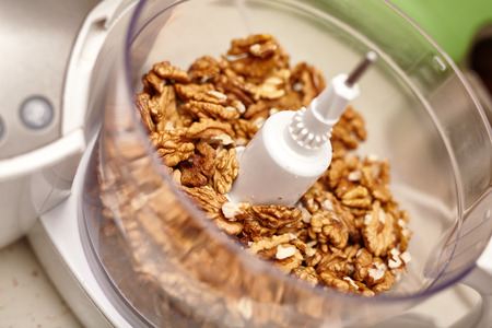 Kernel walnuts in a food processor ready to be crushed for prepare dessert