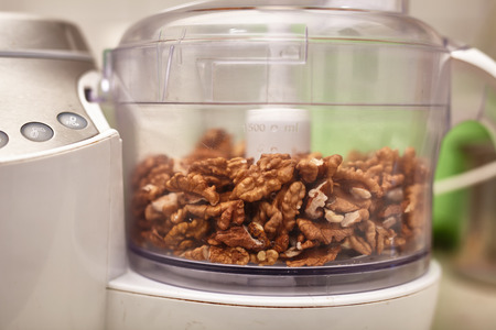 Kernel walnuts in a food processor ready to be crushed for prepare dessert