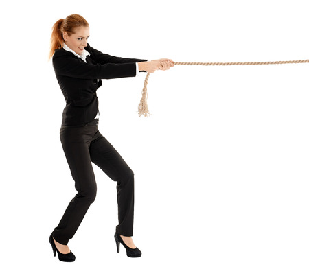 Full length portrait of a businesswoman pulling a rope isolated on white backgroundの写真素材