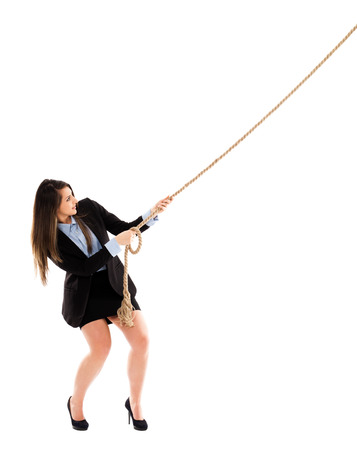 Full length portrait of a sexy businesswoman pulling a rope, with copy space available, isolated on white backgroundの写真素材