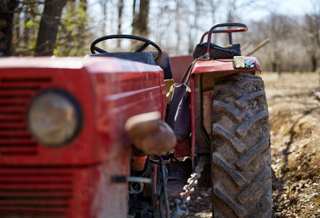 Closeup of an old dirty tractor on a field, with selective focus on tyreの写真素材