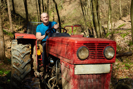 Young farmer driving a logging tractor in a forestの写真素材