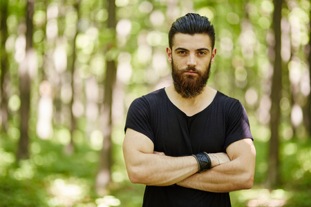 Fashionable young man posing in the woods
