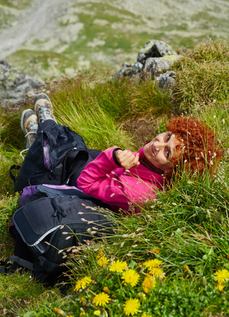 Woman resting on a mountain trail in a summer dayの写真素材