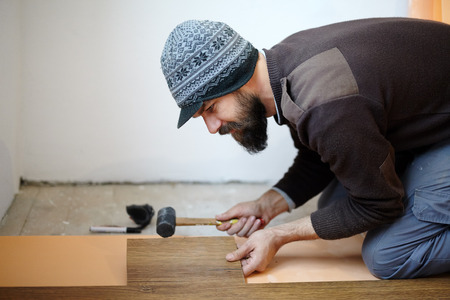 Handy man worker laying parquet in a roomの写真素材