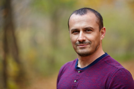 Closeup of a handsome mature caucasian man outdoor in the forestの写真素材