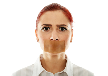 Muted businesswoman with adhesive tape over her mouth, closeupの写真素材