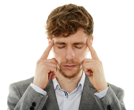 Young businessman having a strong migraine, isolated on whiteの写真素材