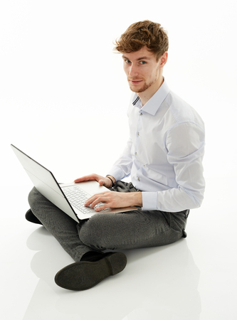 Young businessman working on his laptop on white backgroundの写真素材