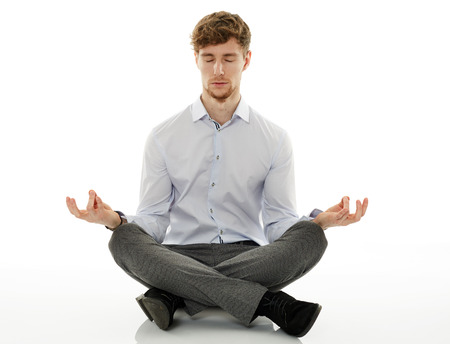Calm and relaxed businessman meditating, sitting with his legs crossedの写真素材