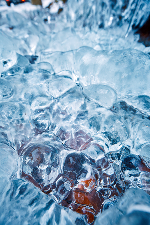 Frozen icicles on rocky wall at the mountain, closeup with selective focusの写真素材