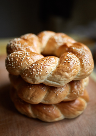 A stack of bagels on a wooden board in closeup