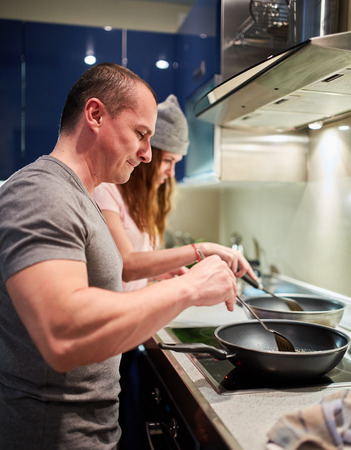Couple cooking at home thai recipe with frying pans on the stoveの写真素材