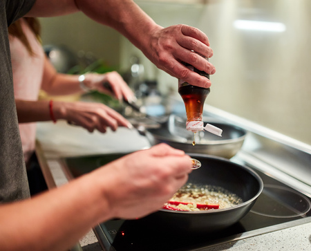 Couple cooking at home thai recipe with frying pans on the stoveの写真素材