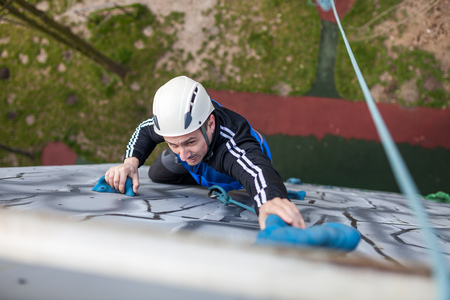 Man climbing up a wall in an exercise for mountaineering