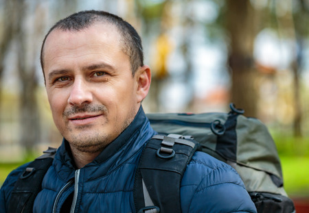 Closeup of a hiker with backpack outdoor over blurred background