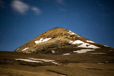 Landscape with a mountain peak and stars at midnightの写真素材
