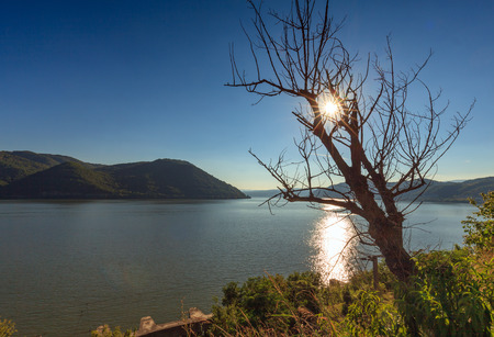 Landscape with the Danube river and surrounding limestone mountains in Romaniaの写真素材