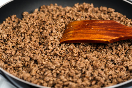 Minced beef meat in the frying pan to prepare cottage pieの写真素材