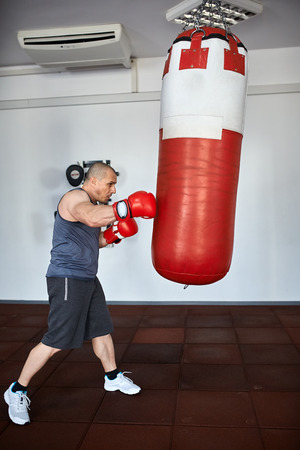 Boxer training with punch bags in a gymの写真素材