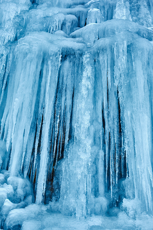 Beautifully shaped icicles on a mountain from a frozen waterfallの写真素材