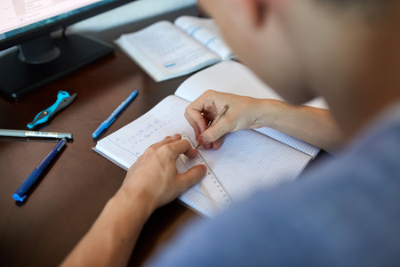 Teenager boy doing homework on his desk at homeの写真素材