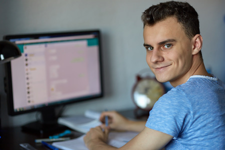 Teenager boy doing homework on his desk at homeの写真素材