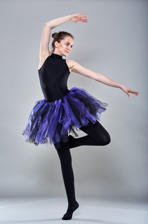 Young ballerina in various postures on gray backgroundの写真素材