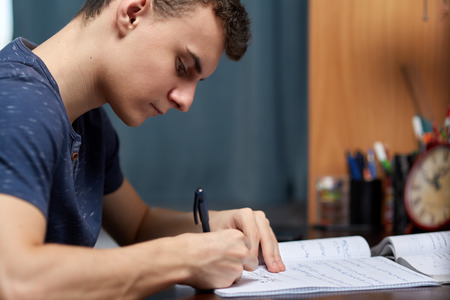 Teenage boy doing homework at his desk at homeの写真素材