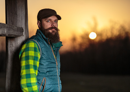 Portrait of a young bearded caucasian farmer outdoor at sunsetの写真素材