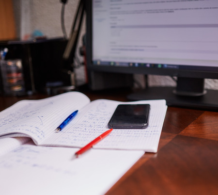Teenager boy doing homework on his desk at homeの写真素材