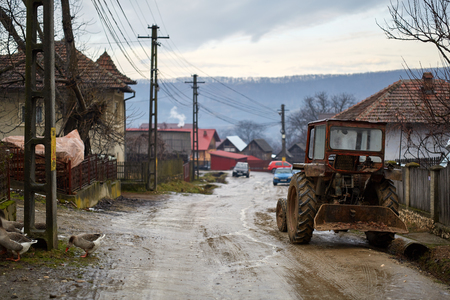 Old tractor parked near a house in a villageの写真素材